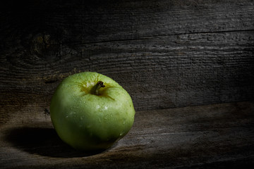 Green apple on wooden table close up with copy space