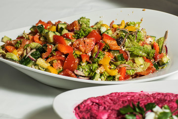 Greek salad with feta cheese, organic kalamata olives, juicy tomatoes, red pepper, red onion, cucumber and lettuce. Concept for healthy nutrition. Tasty and healthy vegetarian meal.