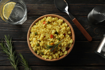 Composition with bowl of delicious rice on wooden background, top view