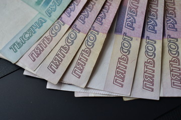 Dollar and ruble bills on a black keyboard