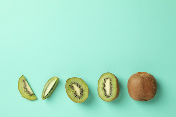 Flat lay with kiwi on green background, top view