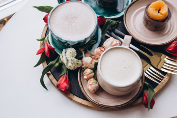 Cups of coffee on white table, top view