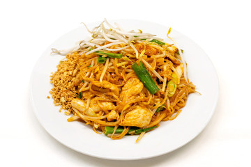 Dish of Pad thai on white background.Pad thai or phad thai, is a stir-fried rice noodle dish commonly served as a street food and at most restaurants in Thailand as part of the country's cuisine. © Chansak Joe A.
