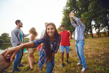 Fototapeta premium Friends have fun running along the lake on a picnic.