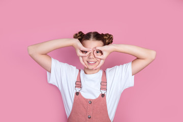 Funny girl showing gesturing ok sign with her two hands like a glasses and looking at camera