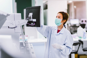 young female laboratory technician working with automation blood  analyzer in medical laboratory