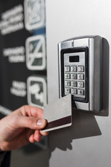 Door access control. Man hand holding key card to lock or unlock door.