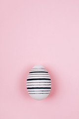 Easter egg on trendy pink pastel background. Flat lay style.