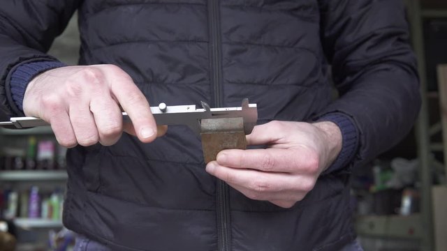 Arbeiter misst Stahlblock 