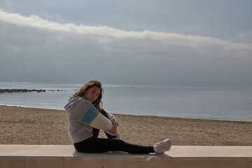 Fototapeta na wymiar Girl watching the sea sit close to the beach in Marbella