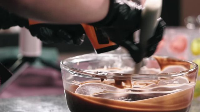 Stirring melted chocolate in the glass bowl with the shovel