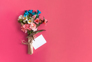 Spring flowers bouquet and greeting card. A bouquet on the bright pink background. Top view of spring floral background with copy space