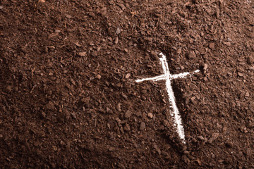 White cross engraved on the ground with the finger