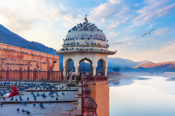 Rotunda of Amber Fort, indian lady feeding pigeons by the Maotha Lake, Jaipur, India