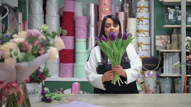 The florist collects a beautiful bouquet of purple tulips.