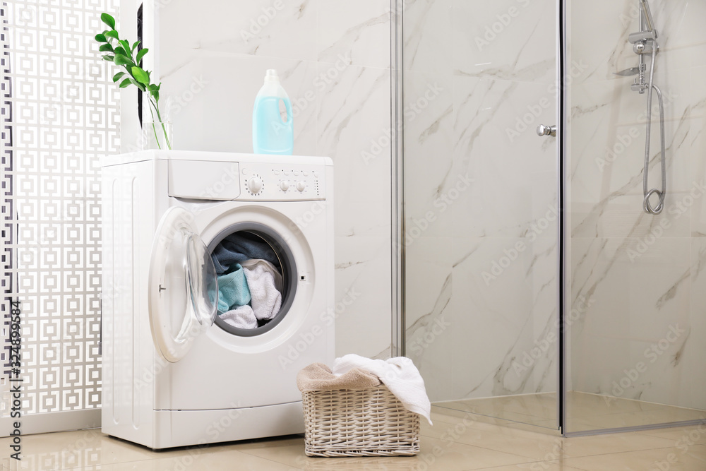 Poster Modern washing machine with towels in bathroom