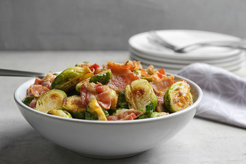 Delicious roasted Brussels sprouts with bacon served on light grey table