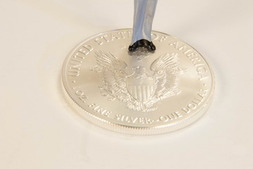 A miniature male figure standing on a US silver eagle coin