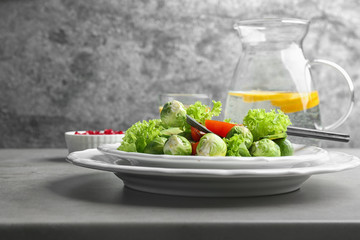 Tasty salad with Brussels sprouts served on grey table