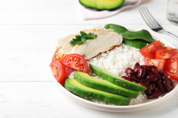 Delicious rice with beans and meat served on white wooden table, closeup
