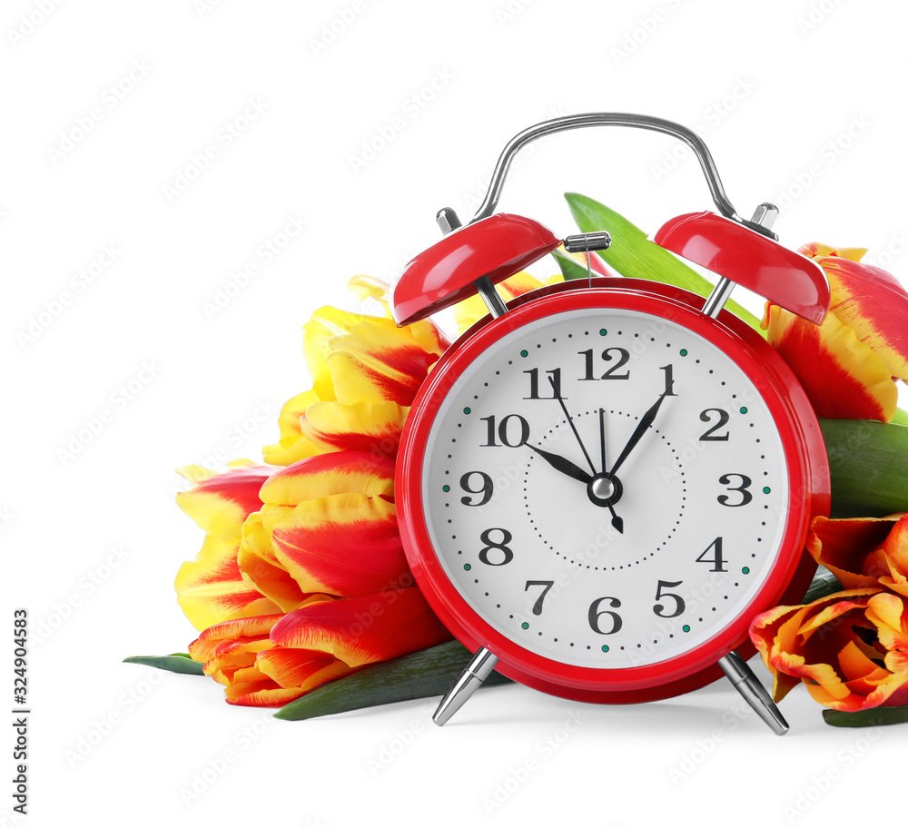 Poster red alarm clock and spring flowers on white background. time change