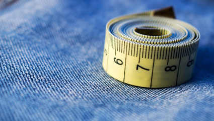 The measuring tape is on the blue jeans.