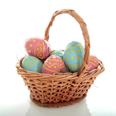 Basket full with chocolate easter eggs over white background