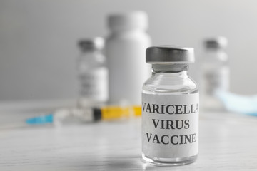 Chickenpox vaccine on white wooden table, space for text. Varicella virus prevention