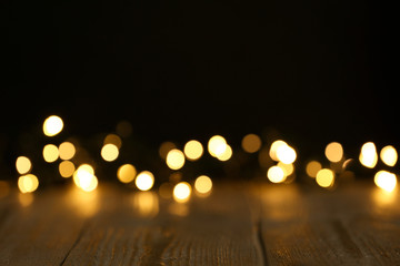 Wooden table and festive lights. Bokeh effect