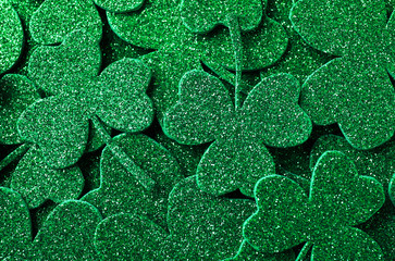 Glitter green clover leaves as background, top view. St. Patrick's Day celebration