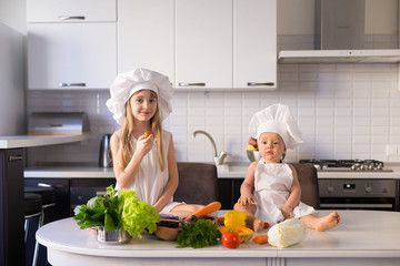  little girl and boy, white chef hat, vegetables