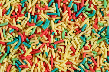 Fototapeta na wymiar Extreme close up, top down view of colorful sugar sprinkles. Macro food texture background
