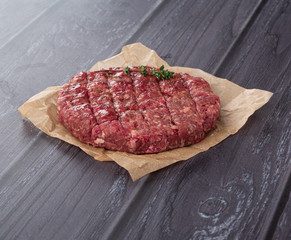 Burger cutlet on craft paper with pepper and spices