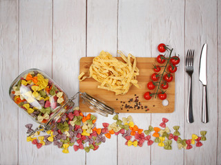 Dry Italian pasta fettuccini and farfalle with tomatoes, rosemary, mixture of peppers and glass jar