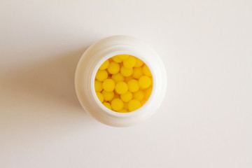 Yellow round tablets or vitamins in a white bubble, on a white background. Concept of medicine. Alternative homeopathy. Flatley. The view from the top. copyright for text.