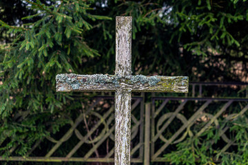 Old vintage wooden Christianity cross  in the background of the metal fence in nature.