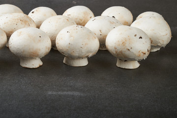 Fresh champignon mushrooms on wooden table, closeup. Space for text