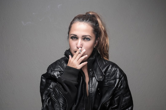 Portrait Of Beautiful Woman In Leather Jacket Smoking A Cigarette.