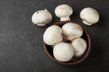 Fresh champignon mushrooms on wooden table, closeup. Space for text