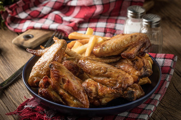 Baked chicken wings with french fries.