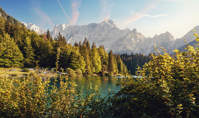 Wonderful Autumn landscape during sunset. Great view on fairy tale Fusine lake under sunlight.  Picturesque view of nature. Amazing natural Background. Best popular places for travew. Beauty of World