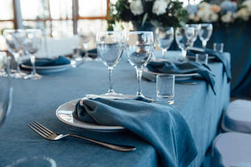 wedding table decor with blue tablecloth and glasses in restaurant