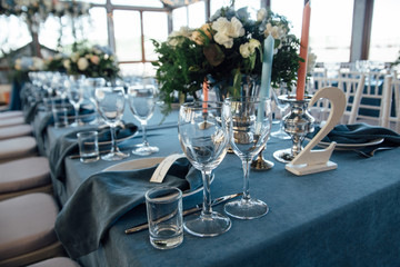 wedding table decor with blue tablecloth and glasses in restaurant