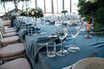 wedding table decor with blue tablecloth and glasses in restaurant
