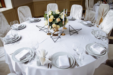 wedding decor on wedding table with white tablecloth and metal decor