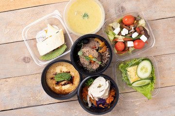 Street food, delivery and clean eating food concept. Variety of clean dieting salads in food boxes on rustic table, top view