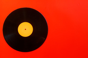 Vinyl record on a red background. Retro style. Top view.