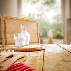 Fresh cold milk on wooden table and kitchen interior.Spring sunny day and free space for your decoration. 