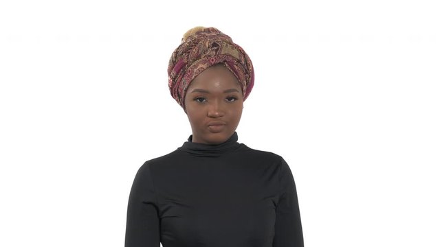 Woman nods her head slightly and looks at the camera. Disapproval, no gesture. Isolated, on white background