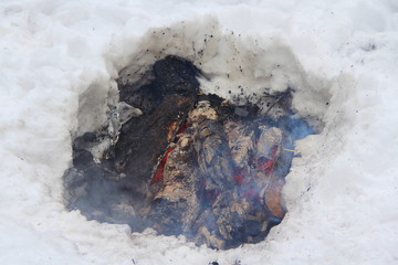 Burning birch firewood in a snow pit, low fire.